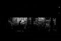 Silhouette d'un passant devant la vitrine éclairée d'une librairie de nuit