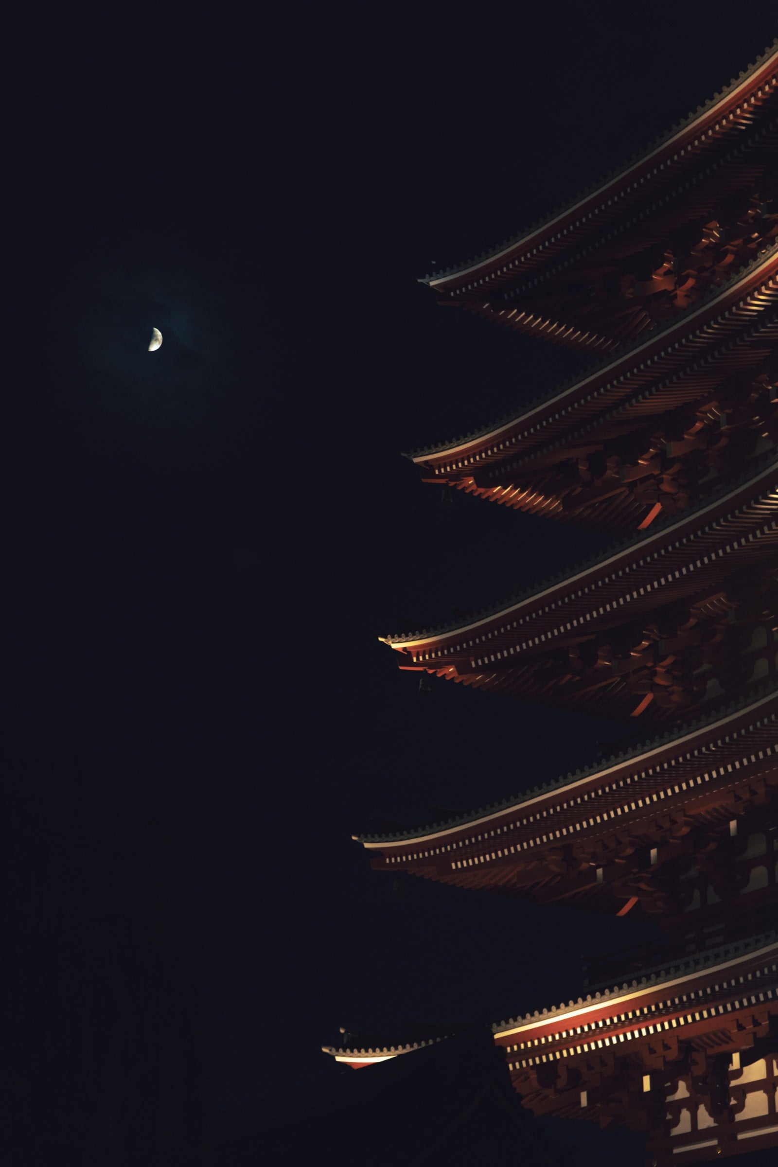 Pagode à cinq étages éclairée la nuit sous un croissant de lune
